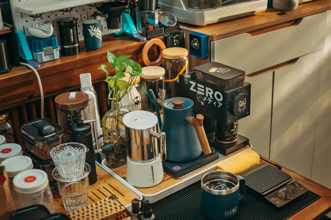 A home coffee station with grinders, mugs, and brewing tools