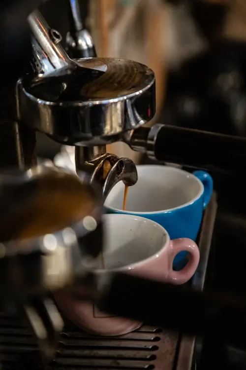 Espresso pouring into two cups from a machine